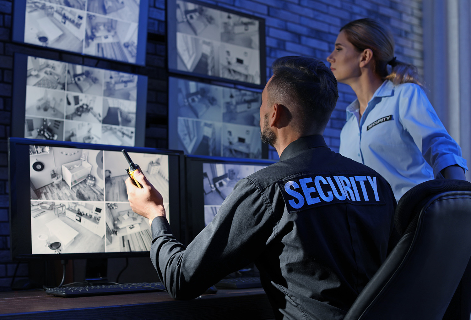 An image of two security guards at a control desk