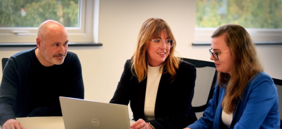 An image of Judy Hegarty and colleagues at a desk